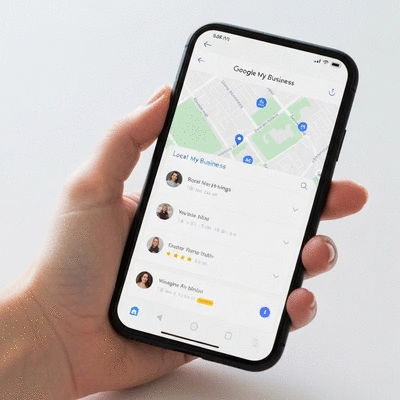Une main tenant un smartphone affichant Google My Business avec une carte locale